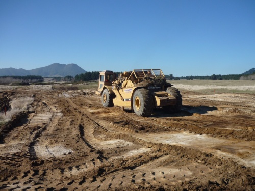 A motor scraper stripping topsoil